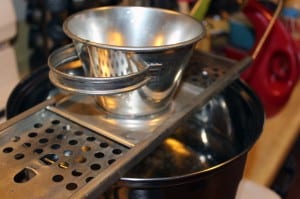 spätzle maker sitting on top of a pot