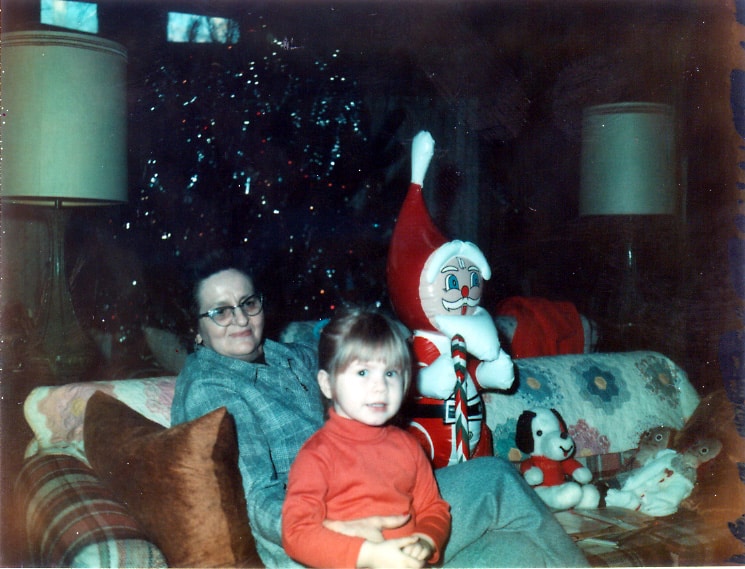 Small child sitting with her Grandma with Christmas presents