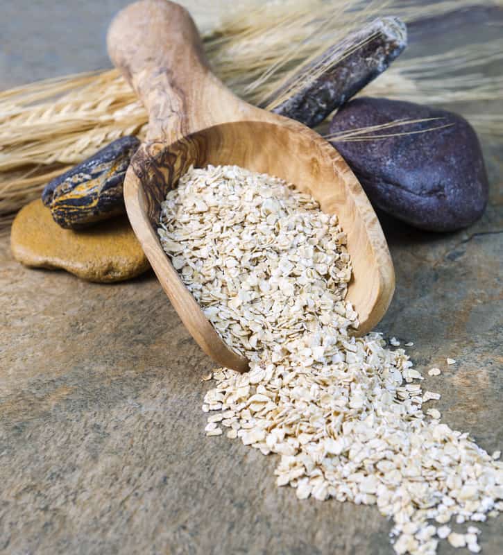 Dry Oat Cereal in wooden spoon on Stone setting